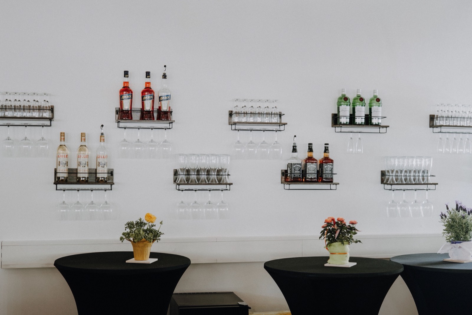 Stehtische und Gläserregale an der Bar